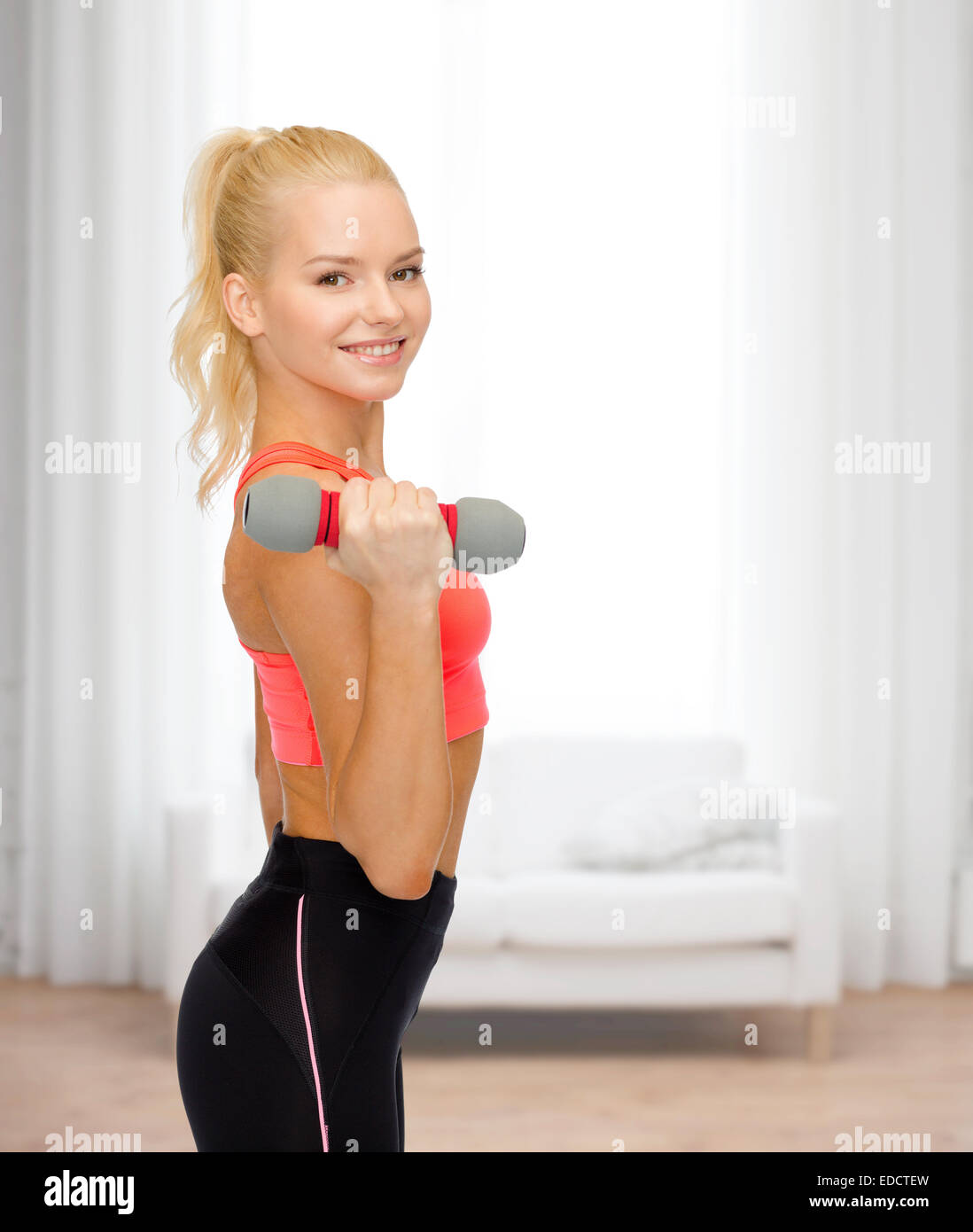 smiling beautiful sporty woman with dumbbell Stock Photo