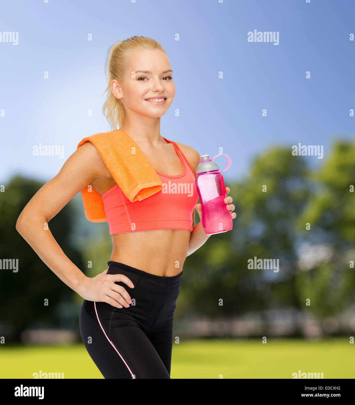 smiling sporty woman with water bottle and towel Stock Photo - Alamy
