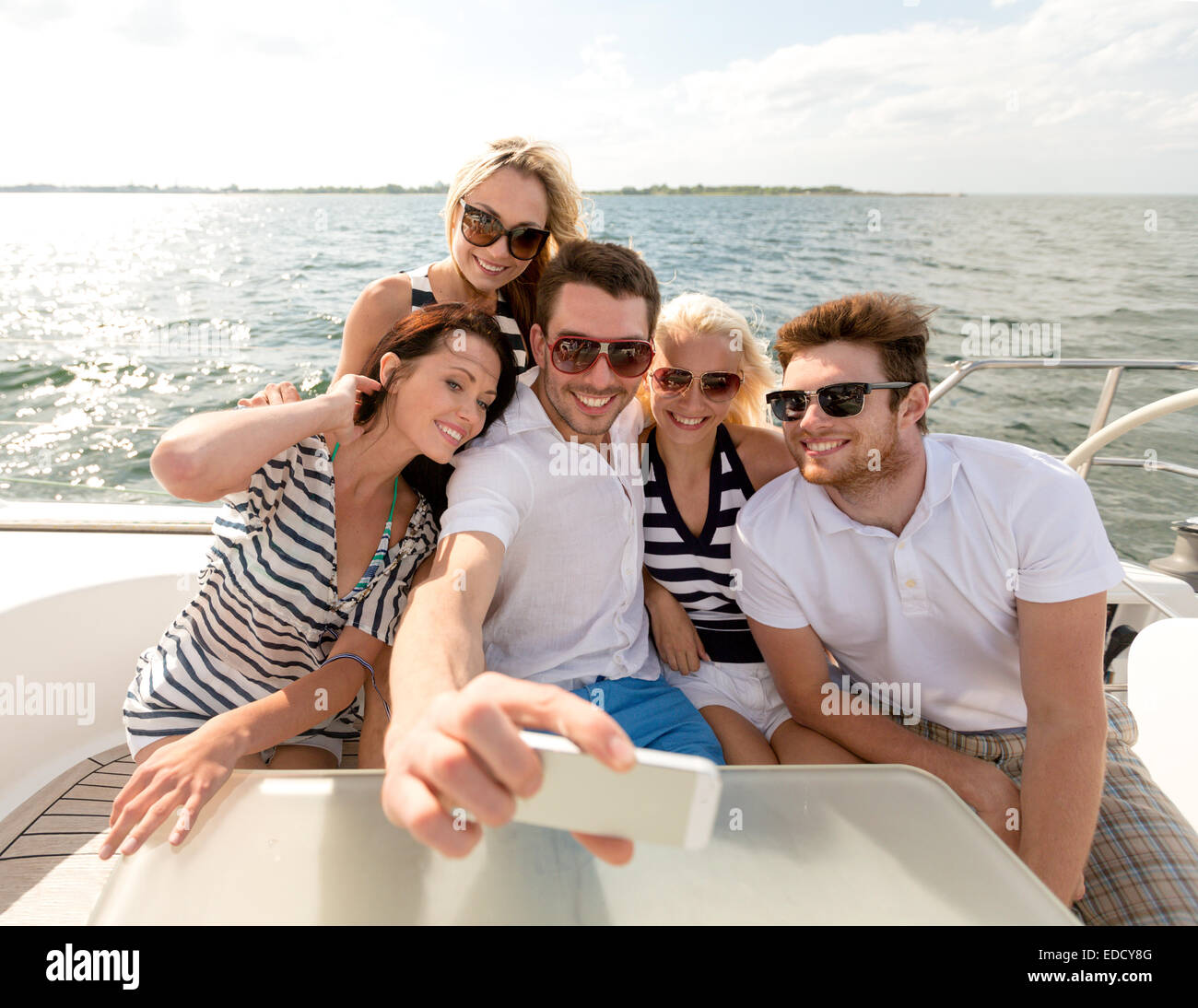 smiling friends sitting on yacht deck Stock Photo - Alamy