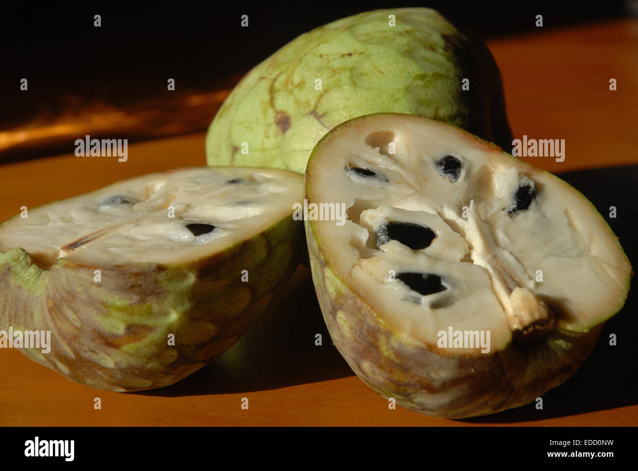 Cherimoya fruit, including one cut open showing the inside. Stock Photo