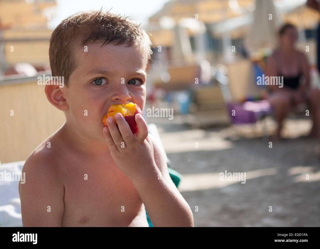 baby eating peach on the beach to the sea Stock Photo Alamy