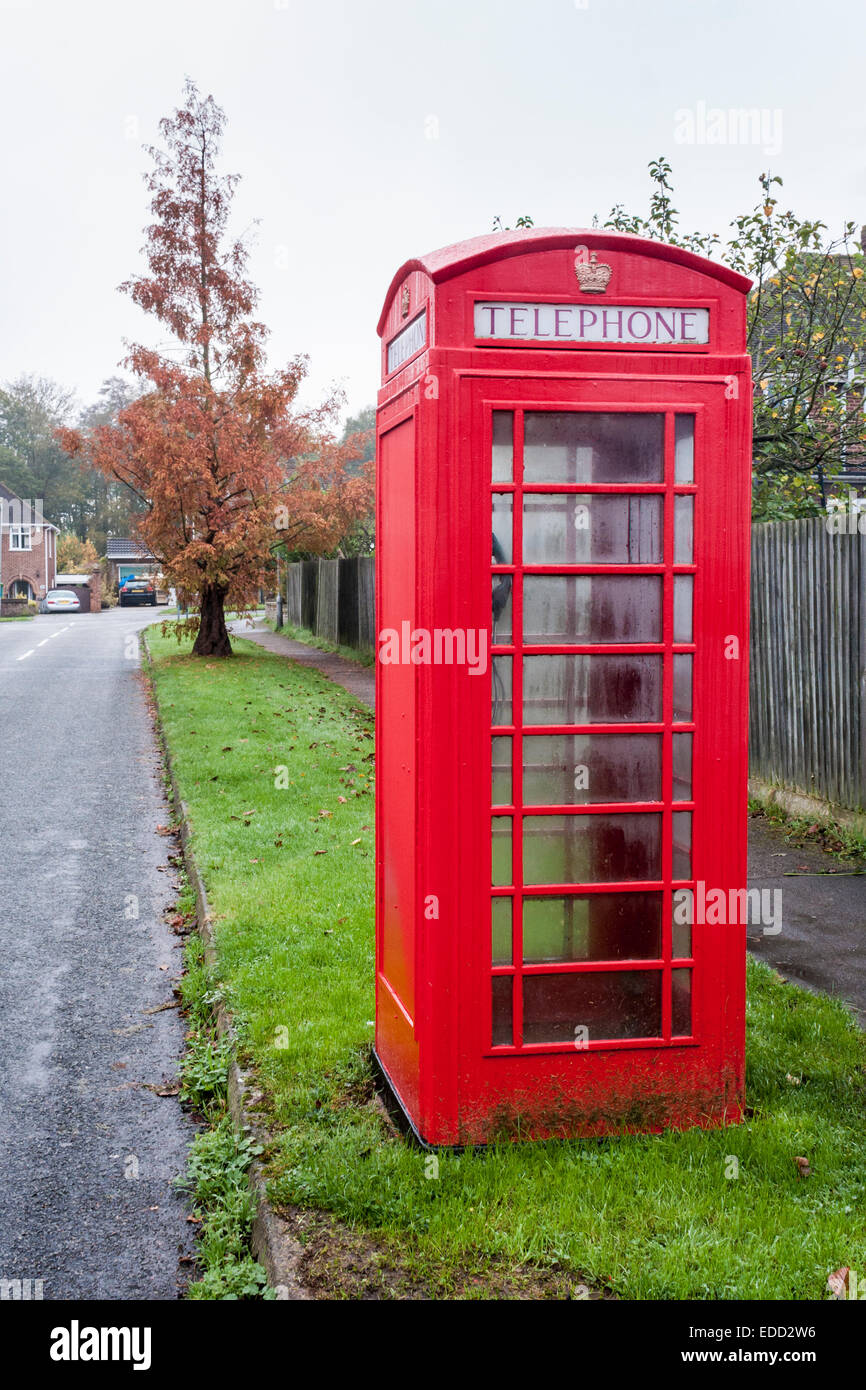 Traditional British red telephone kiosk on a suburban street. Stock Photo