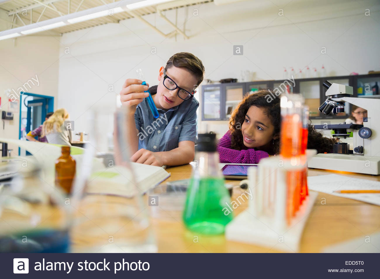 Elementary students examining vial in laboratory Stock Photo Alamy