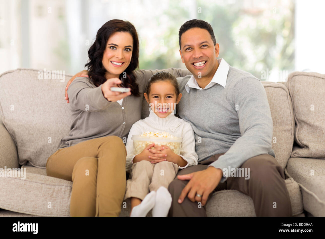 young family watching tv in the living room at home Stock Photo