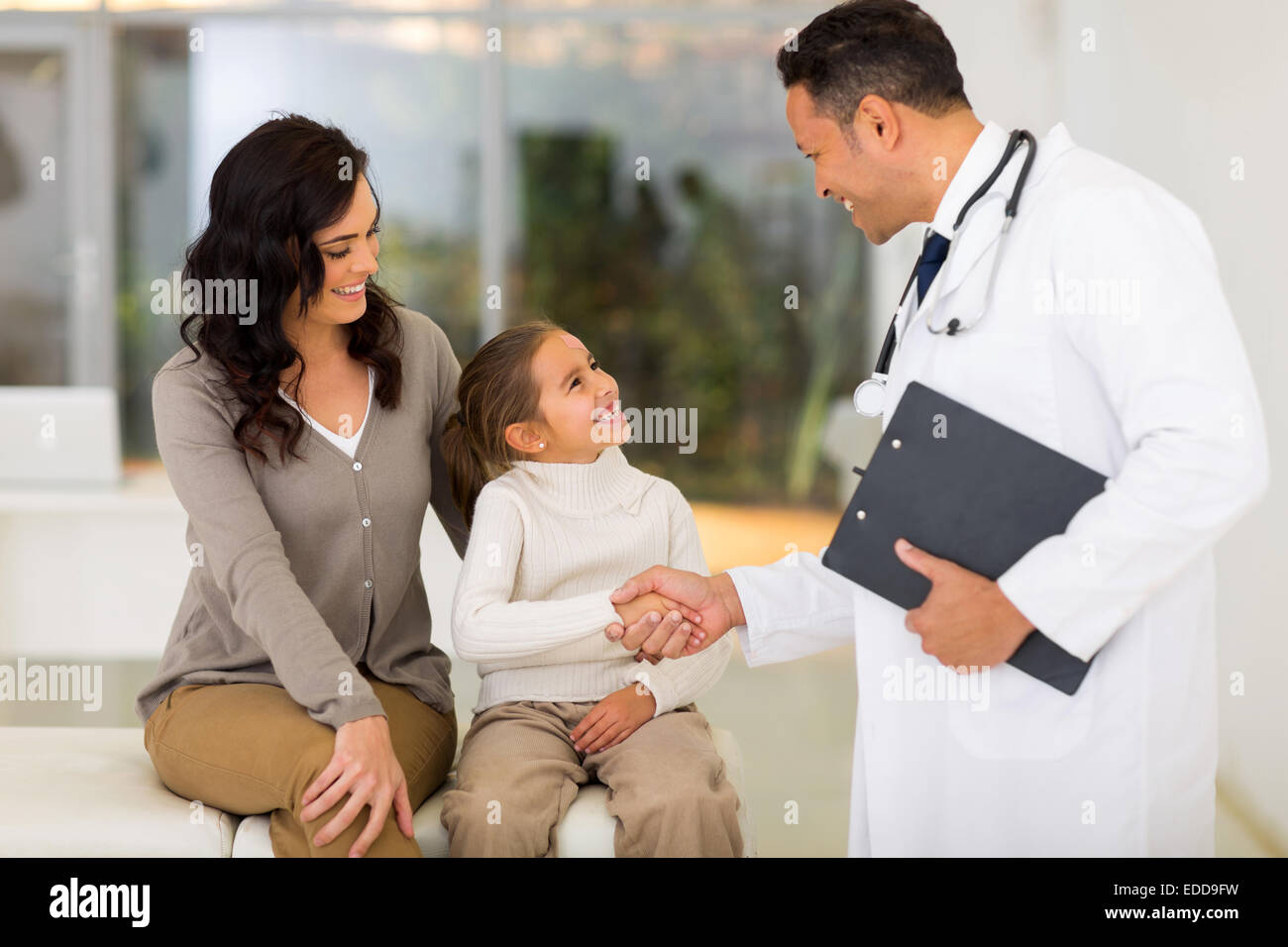 smiling pediatric doctor handshaking little patient Stock Photo