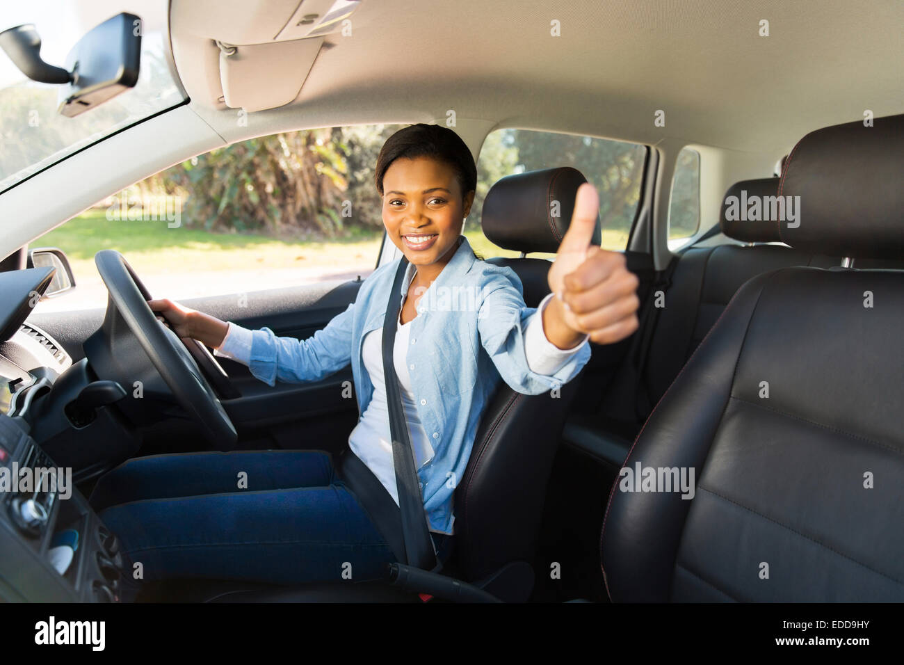 attractive young African female driver giving thumb up inside her new car  Stock Photo - Alamy