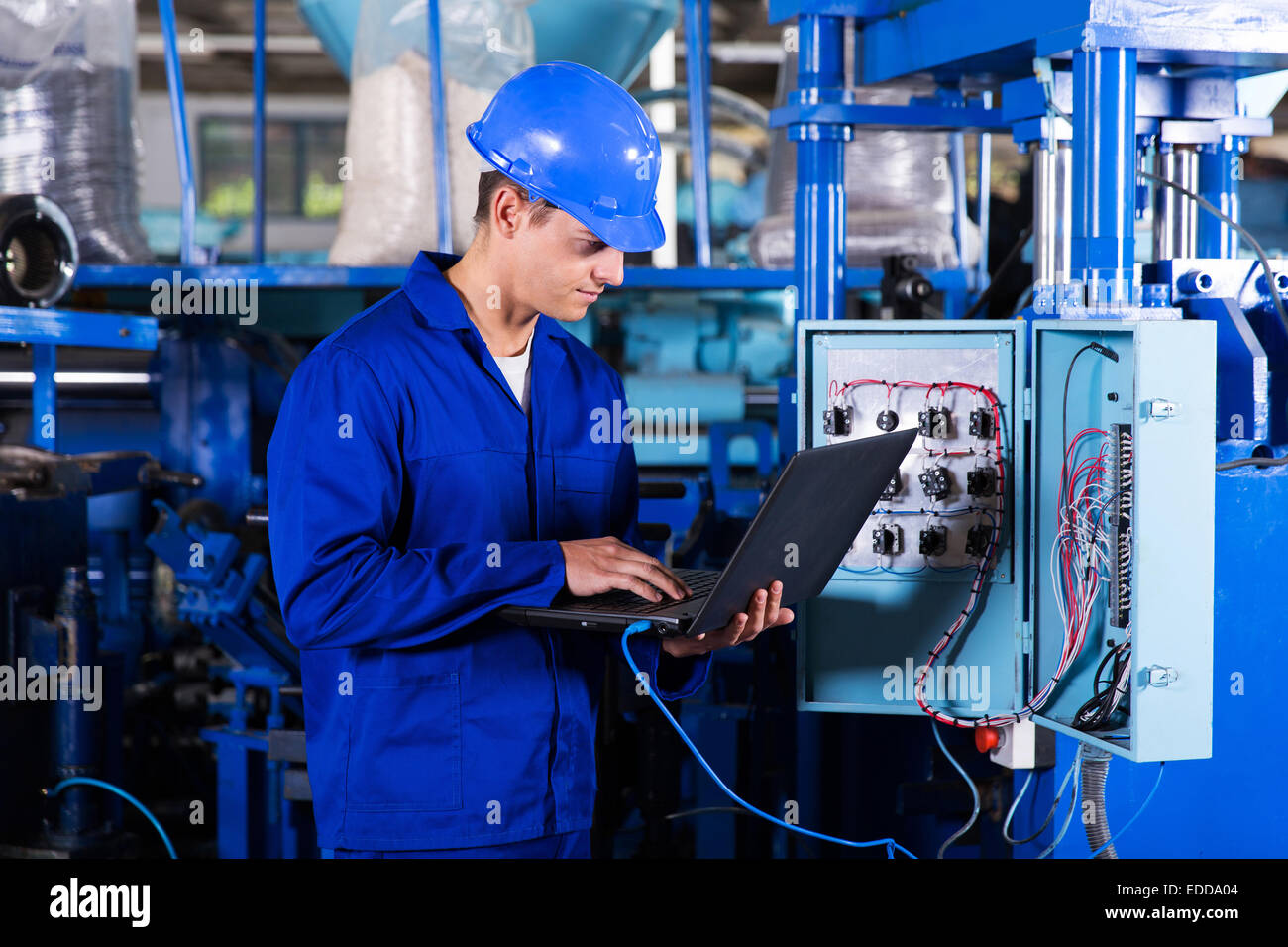 industrial programmer checking control box status with laptop computer Stock Photo
