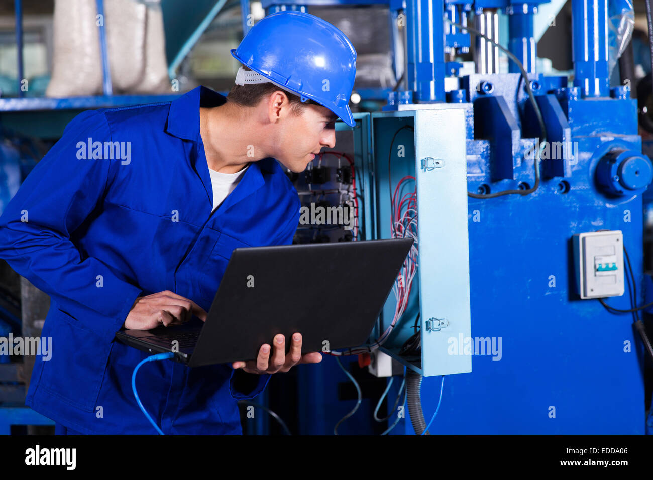 industrial technician checking distribution box with laptop in factory Stock Photo