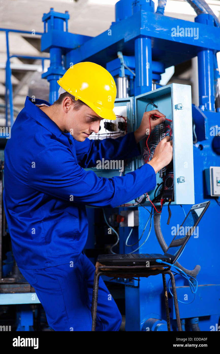 industrial technician repairing modern computerized machine in factory Stock Photo