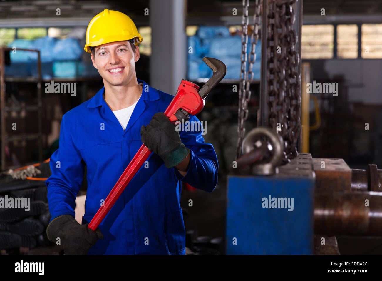 happy factory worker with monkey wrench in workshop Stock Photo