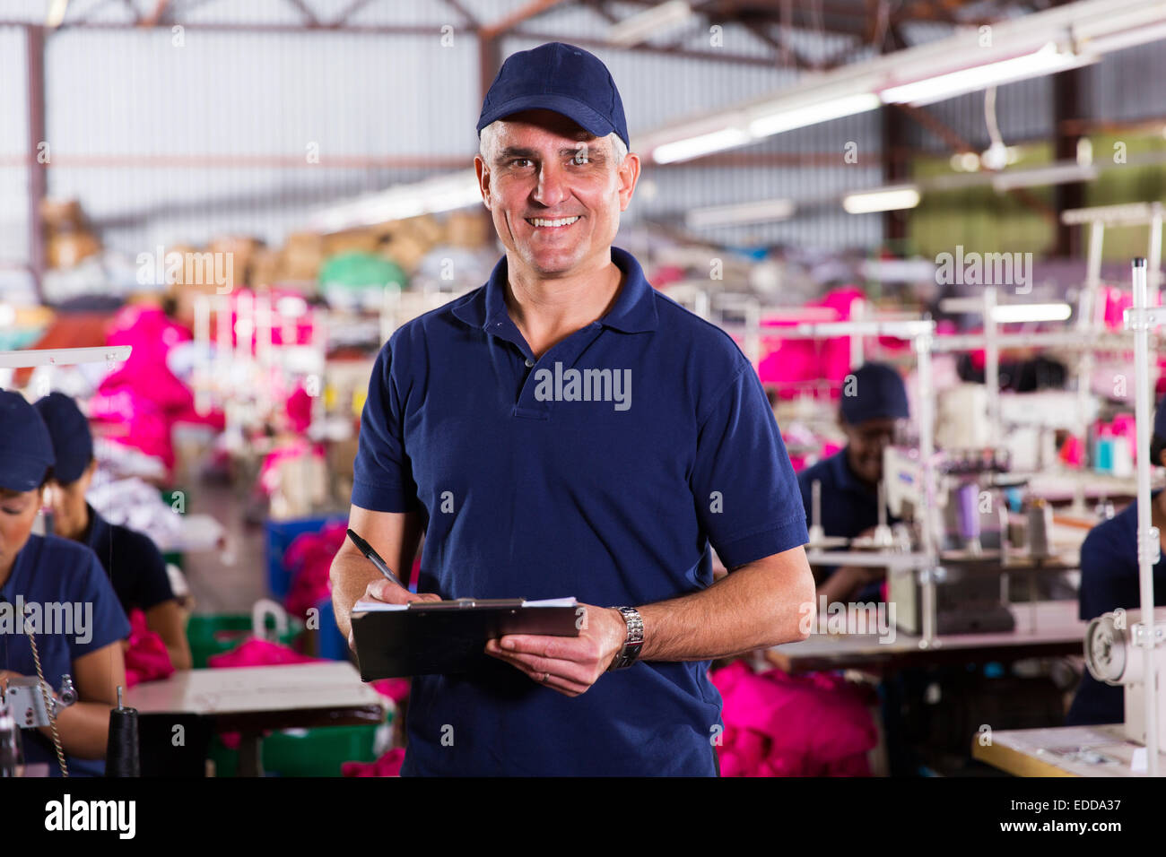 portrait of handsome senior factory supervisor with clipboard Stock Photo