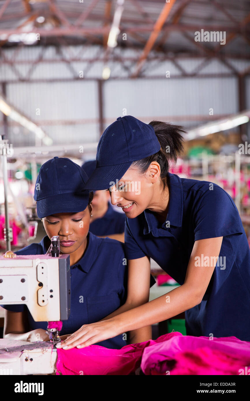 friendly young woman teaching new machinist to sew Stock Photo Alamy