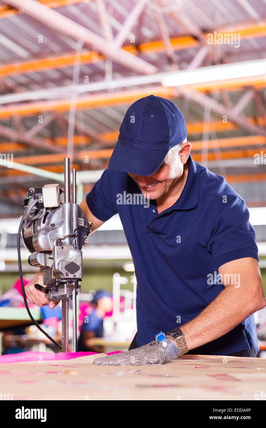 skilled middle aged factory worker using fabric cutter Stock Photo Alamy
