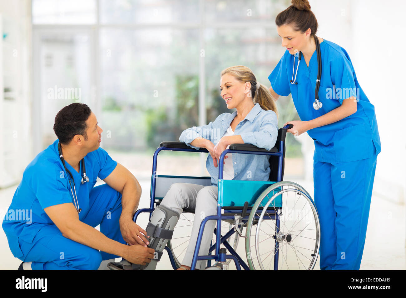 friendly doctor talking to a recovering patient in wheelchair Stock