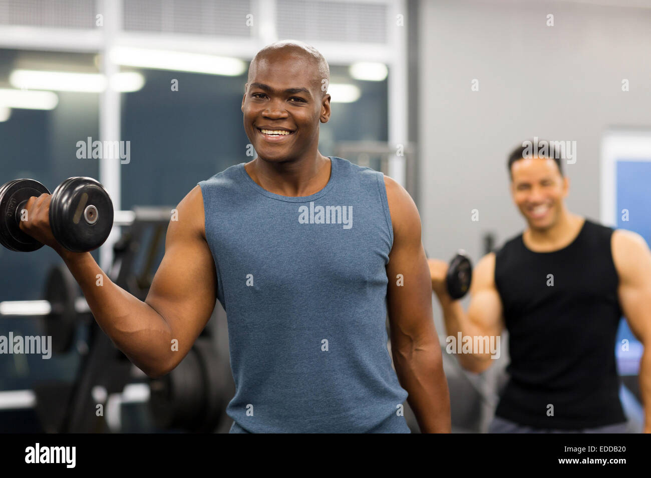 afro American muscle man holding dumbbell looking at the camera Stock Photo