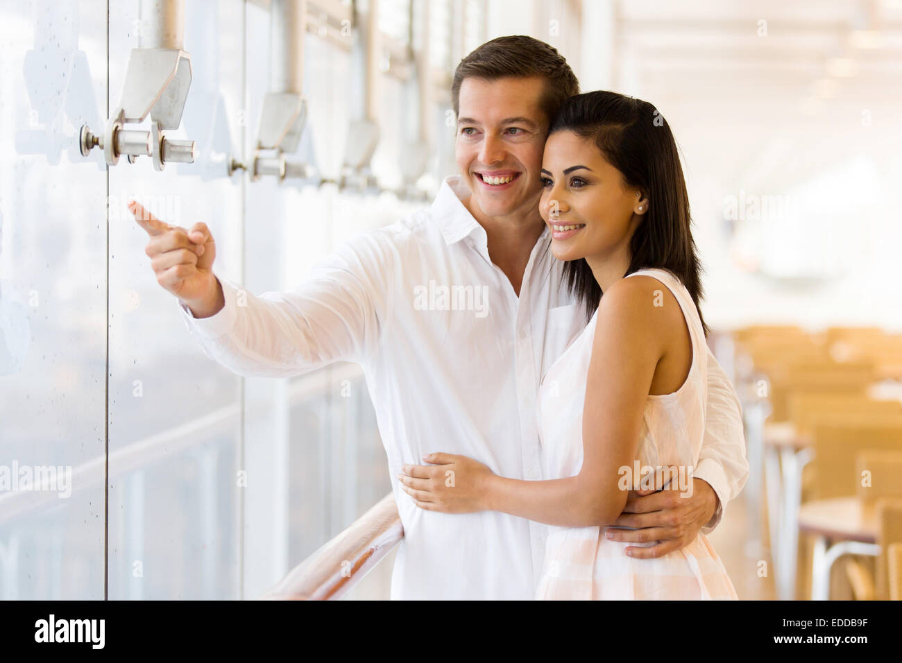 cute couple standing at restaurant and pointing outside Stock Photo