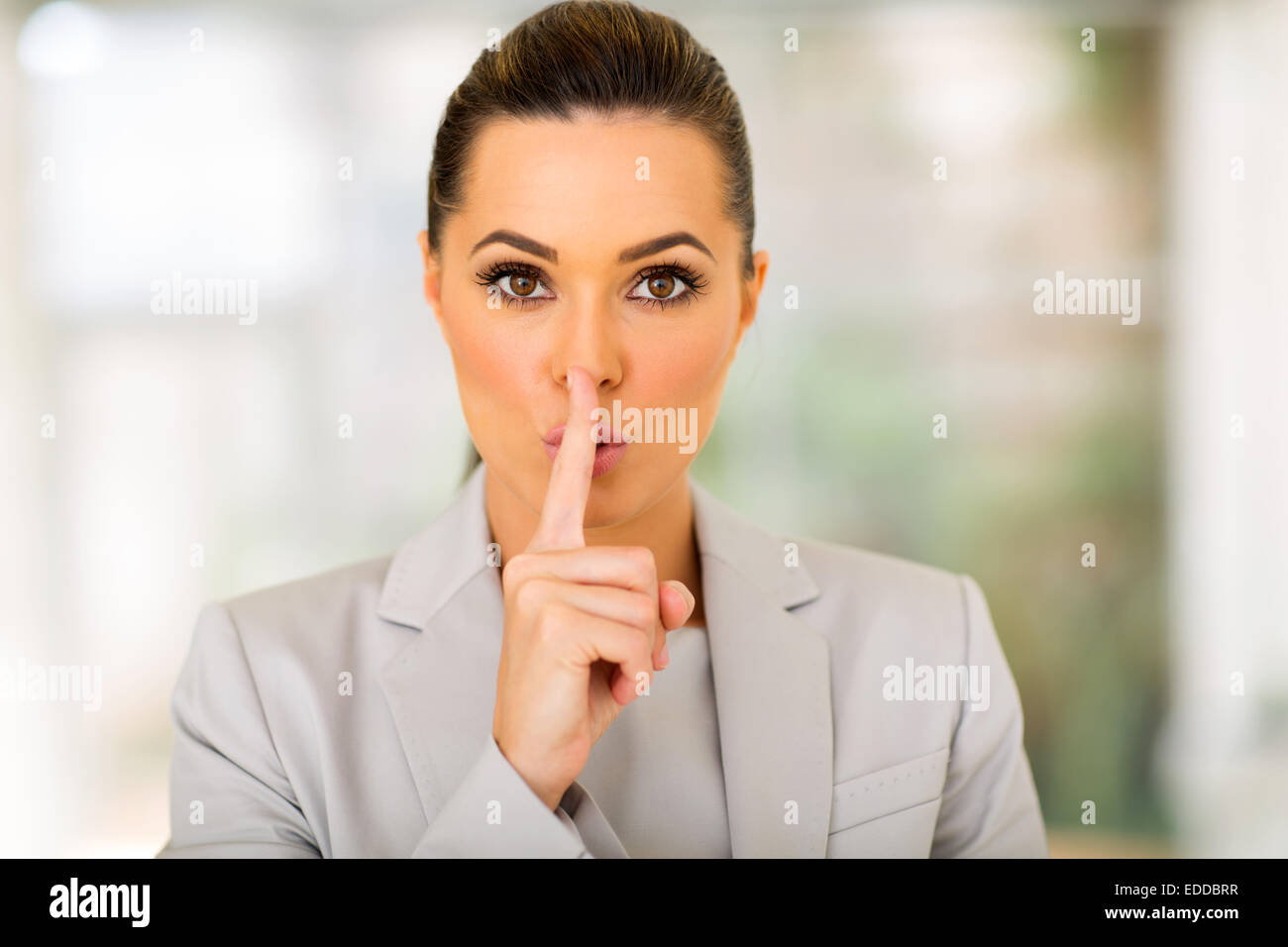 pretty young businesswoman saying shhh Stock Photo