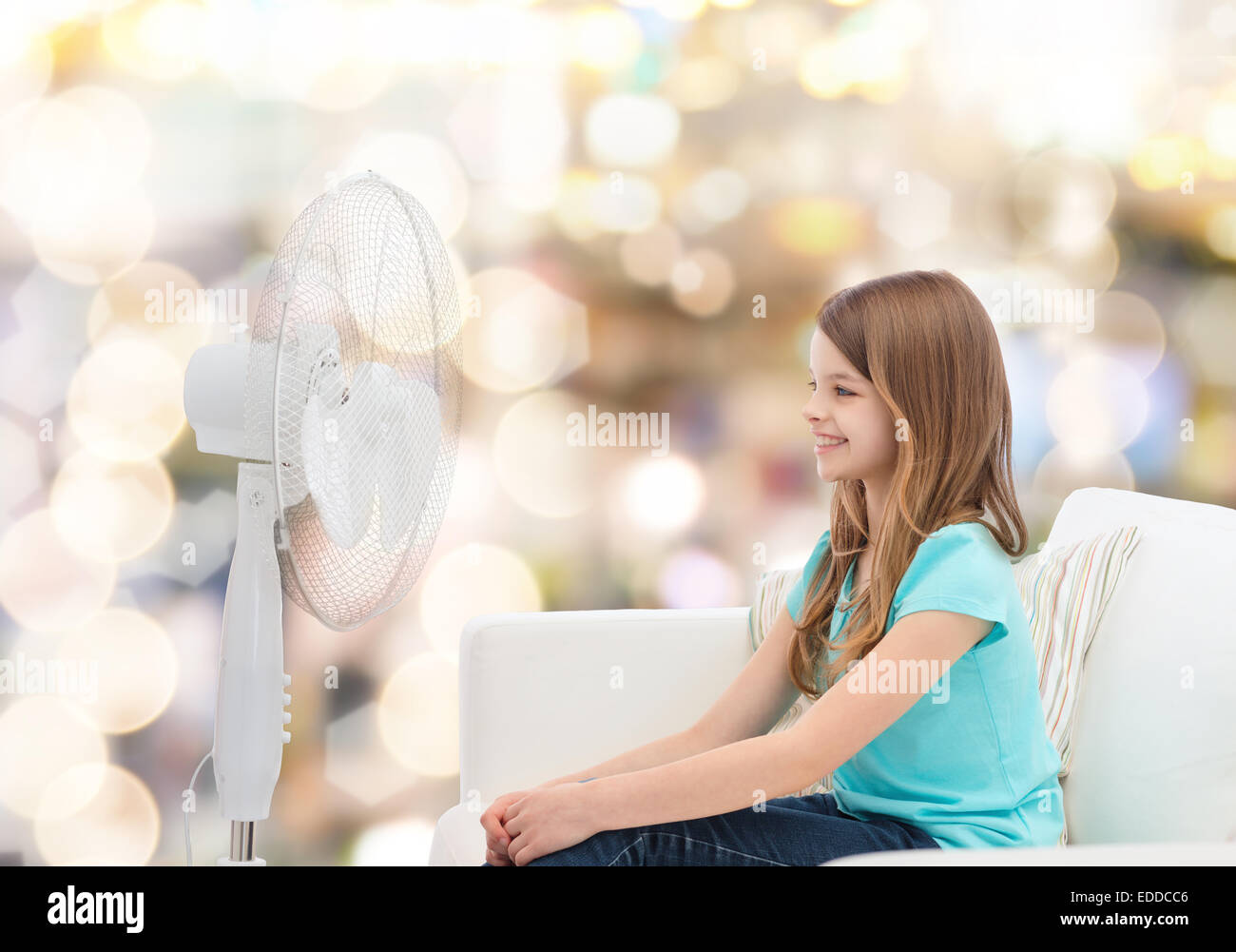 smiling little girl with big fan at home Stock Photo