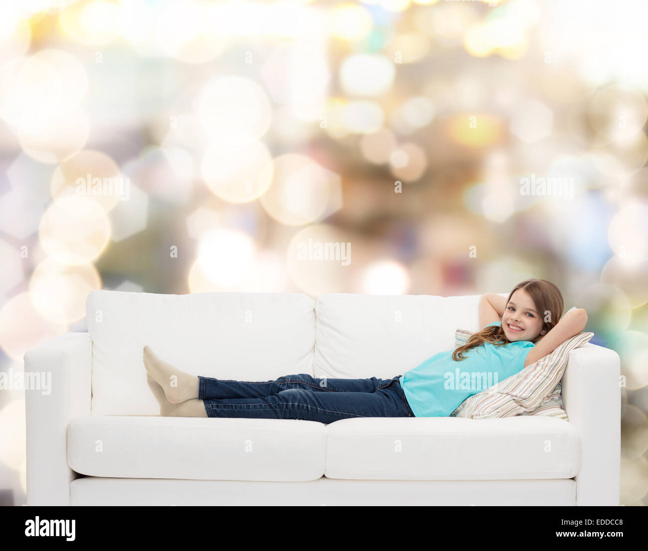 smiling little girl lying on sofa Stock Photo Alamy