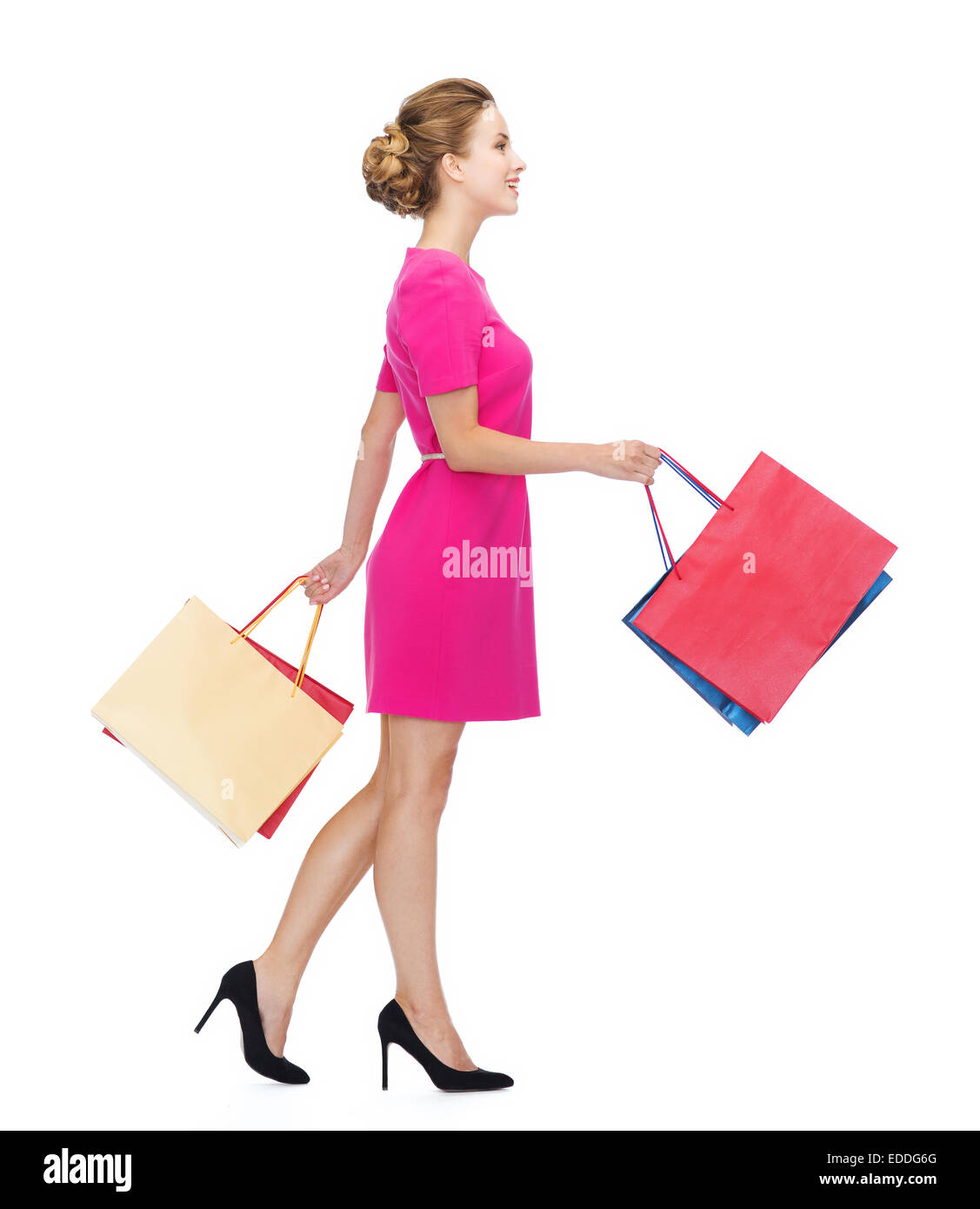 smiling woman in pink dress with shopping bags Stock Photo