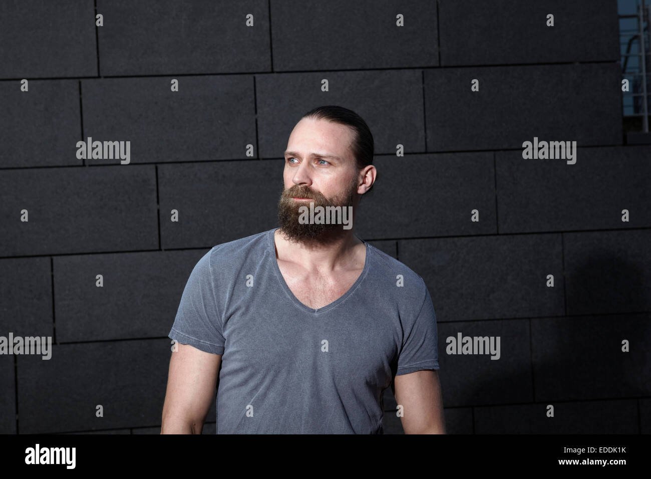 Portrait of man with full beard in front of grey background Stock Photo