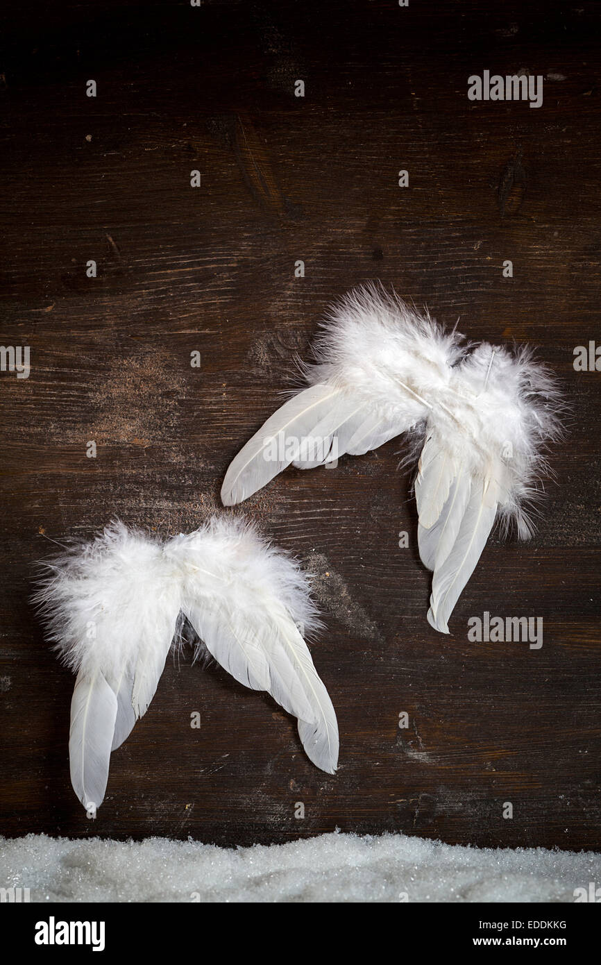 Two angel wings on dark wooden background Stock Photo