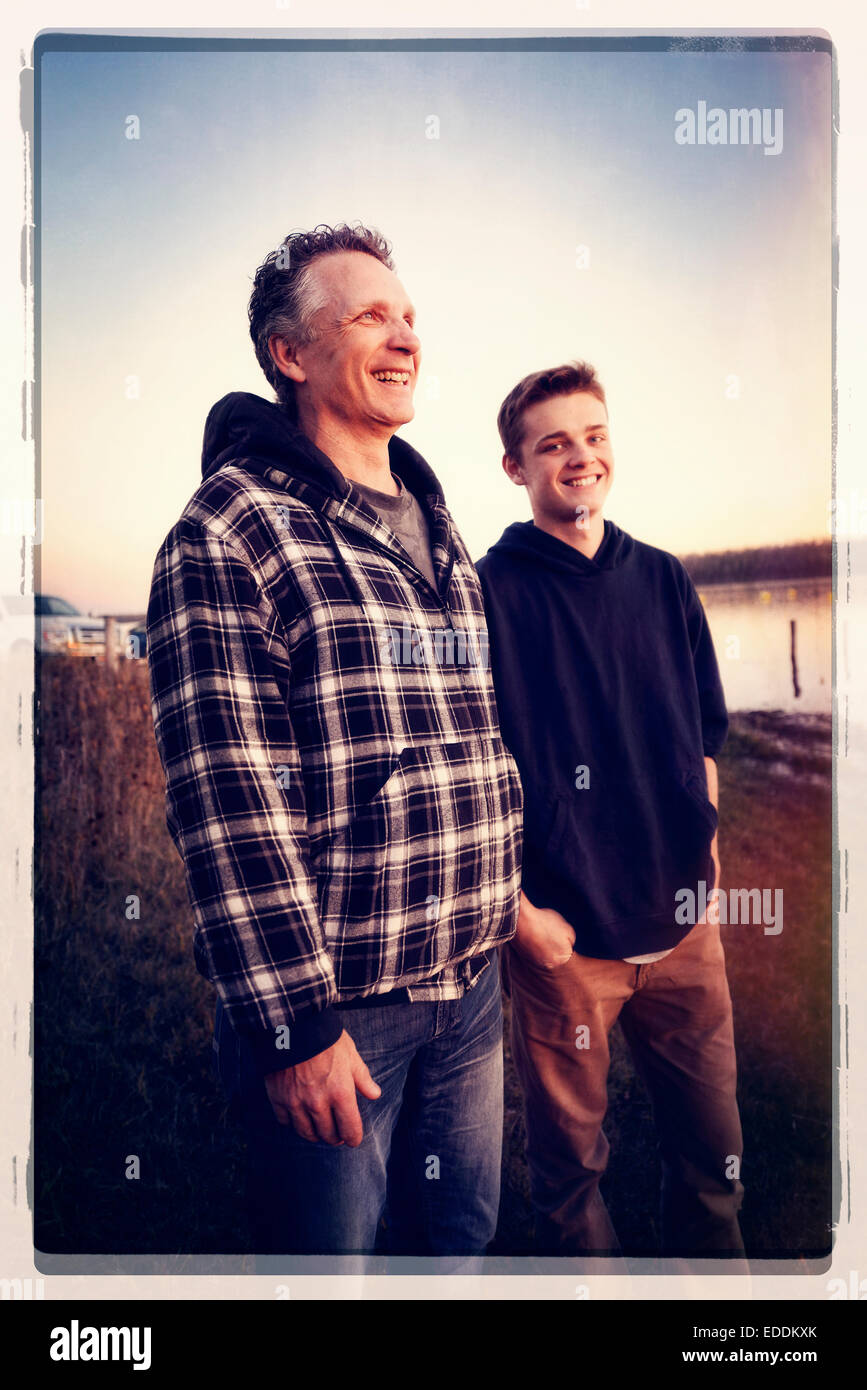 Father and son standing side by side outdoors. Stock Photo