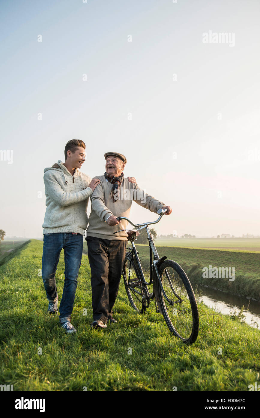 Senior man and grandson in rural landscape with bicycle Stock Photo