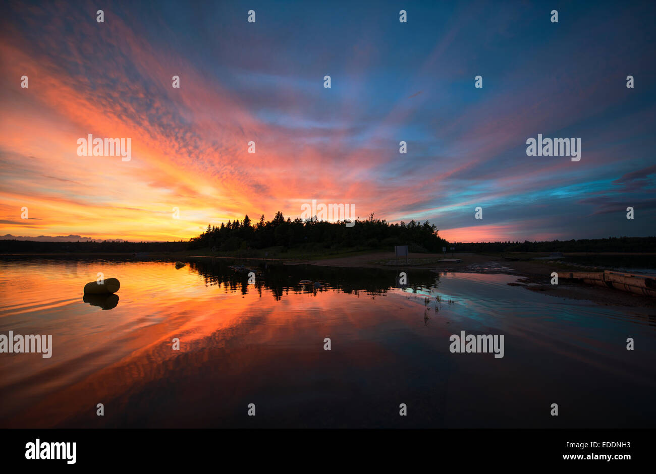 Sunset sky reflected in a lake, and clouds in the sky Stock Photo - Alamy