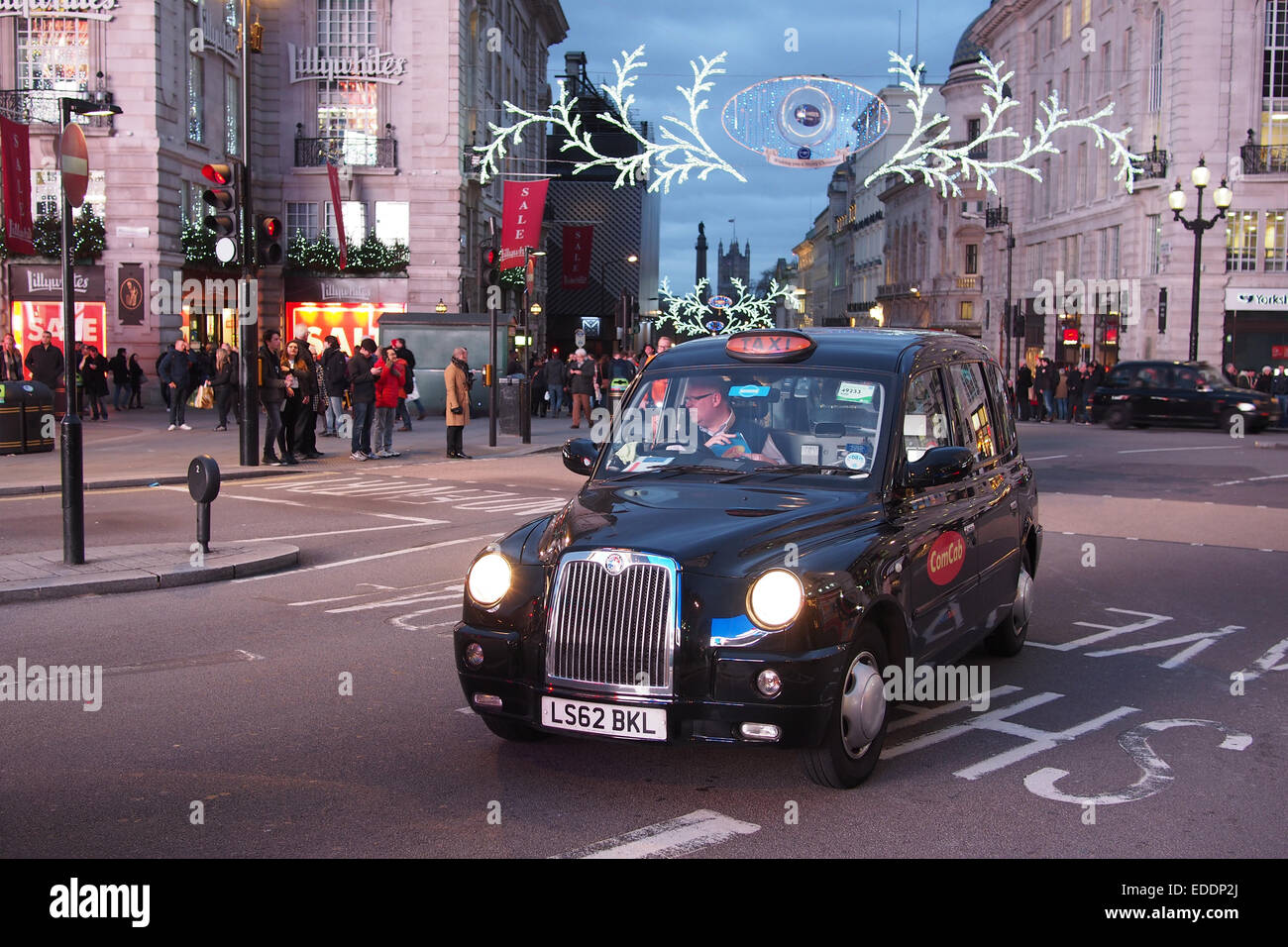 Black cab, London taxi in Piccadilly Circus, London with Christmas lights in background Stock Photo