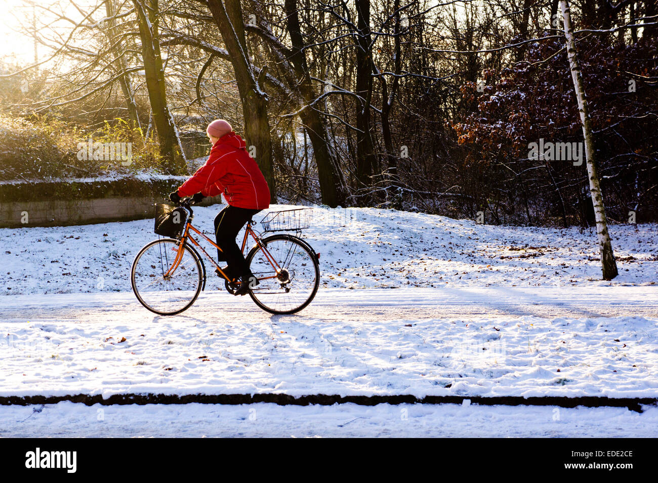woman riding a bicycle in snow Stock Photo