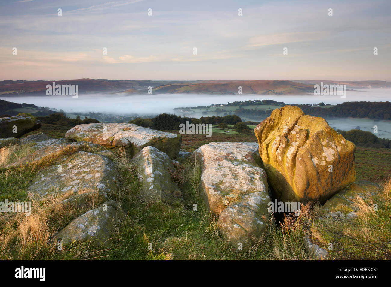 Looking over a misty Hathersage from Carr Head Rocks, the Knuckle Stone gets illuminated from