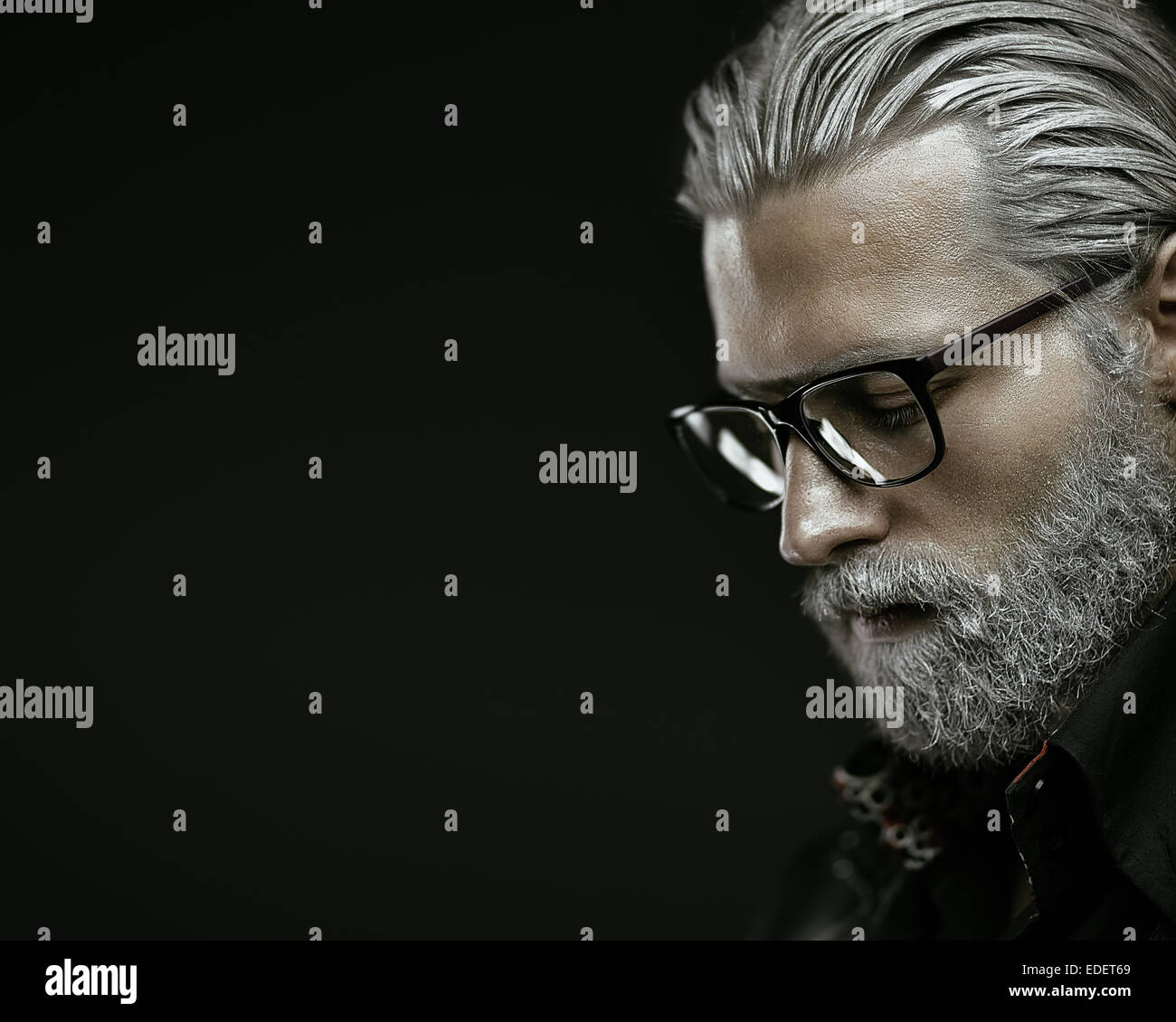Artistic portrait of gray haired man on black background Stock Photo