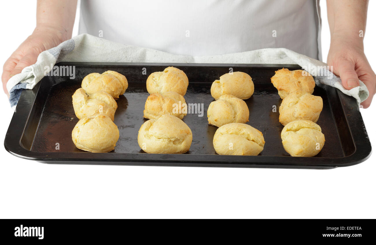 hands holding tray of choux pastry profiteroles Stock Photo