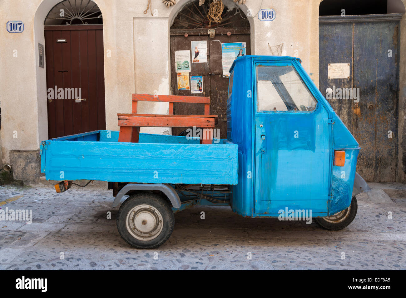 An old Piaggio APE vehicle, truck or scooter in a street in Cefalu Sicily Italy Stock Photo