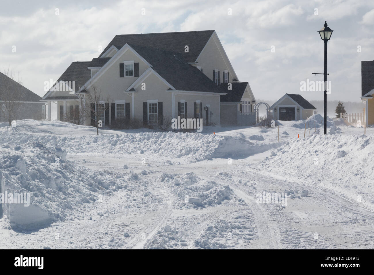 A freshly plowed road in America suburbia during a snow storm. Stock Photo