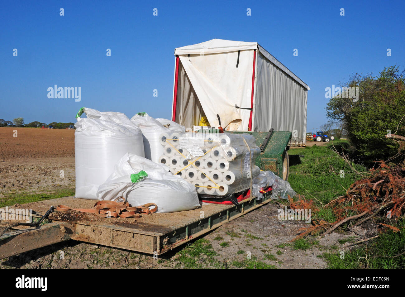 Rolls of polythene for covering sweetcorn seeds and warming the soil.  Work unit.  Tractors preparing the soil.  Coastal Plain. Stock Photo