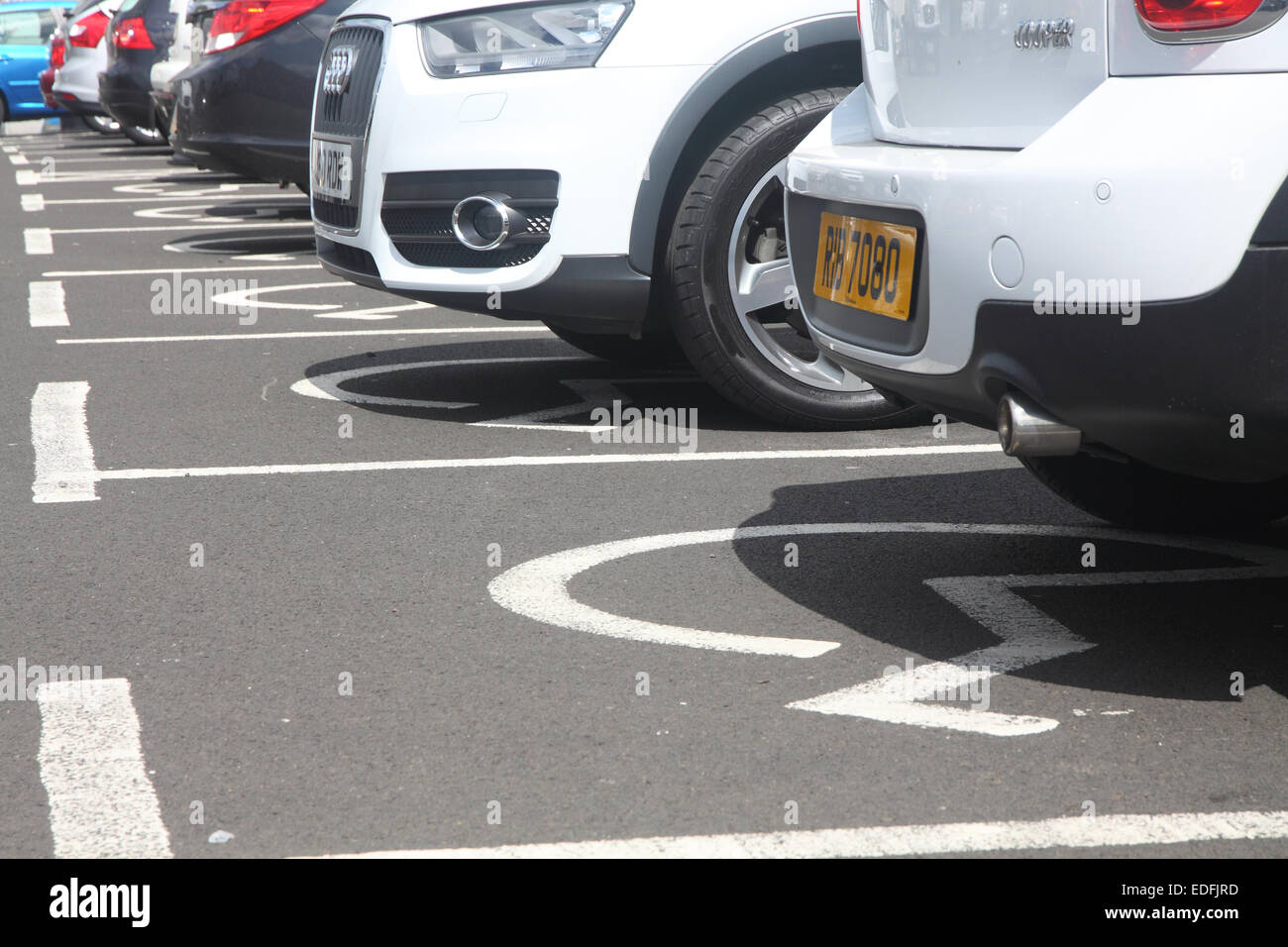 Cars parked in a row of disabled parking spaces Stock Photo