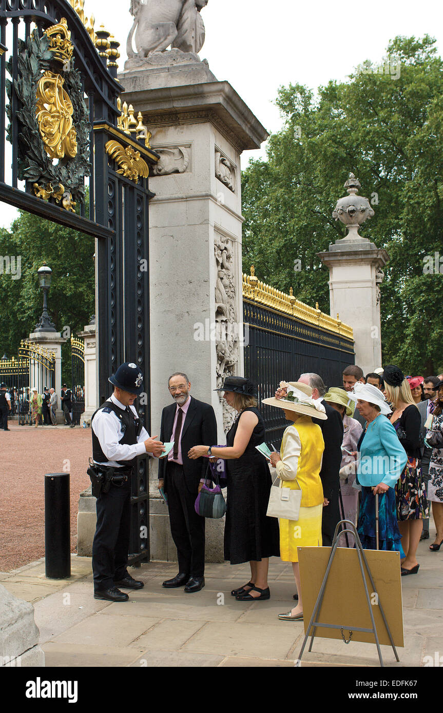 A policeman checks the invitations at the gates of Buckingham Palace before one of the Queen's garden parties. Stock Photo