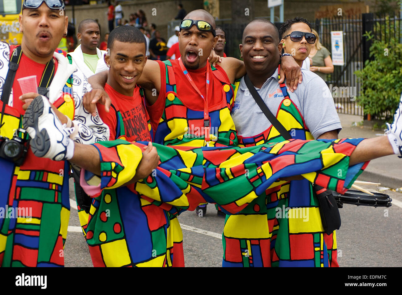 Some friends who are going to be playing in a band fool around for the camera at the Notting Hill Carnival. Stock Photo