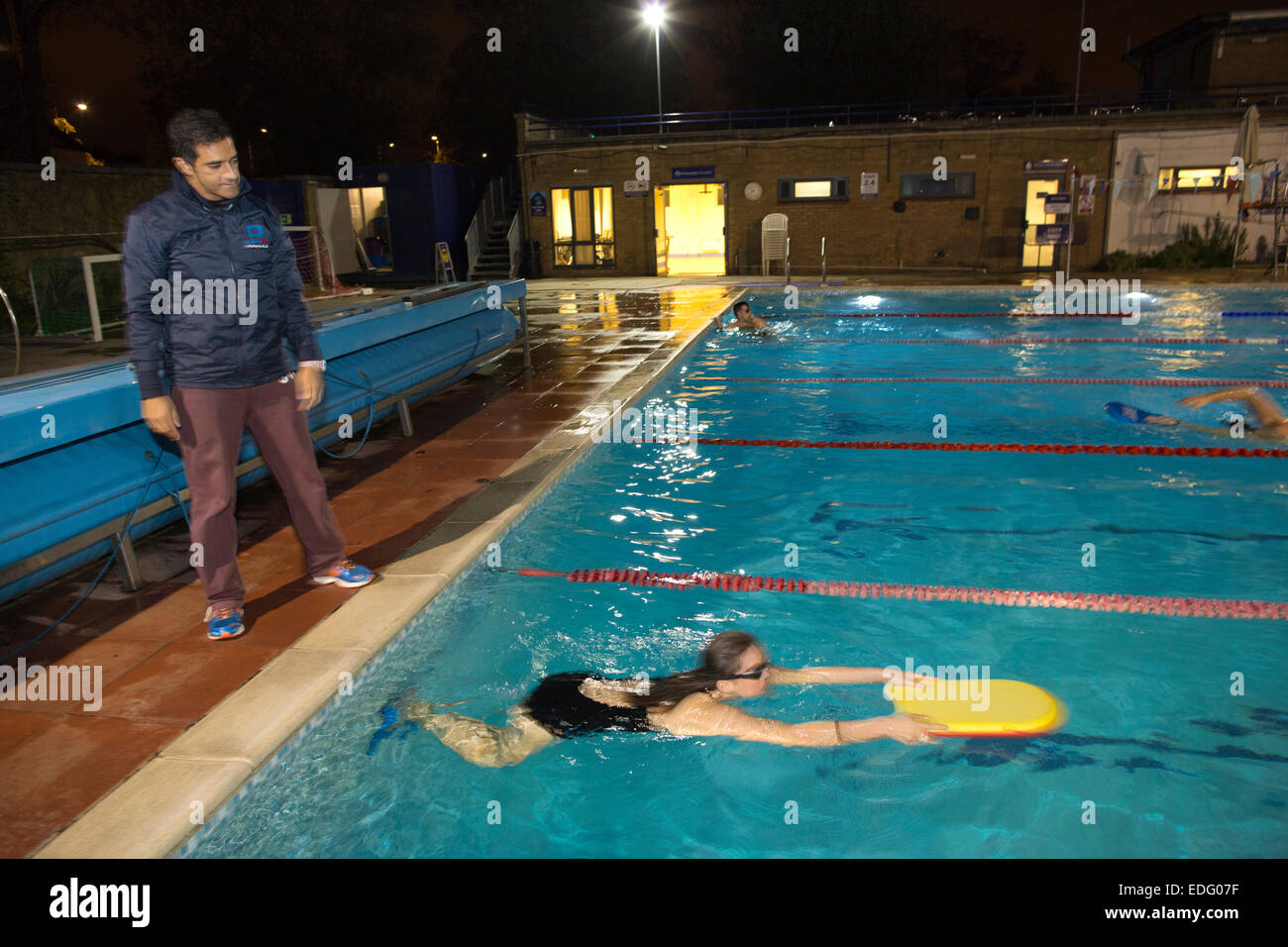 Evening swimming lessons given by Salim Ahmed outdoors at Hampton Pool, Middlesex, England, UK Stock Photo
