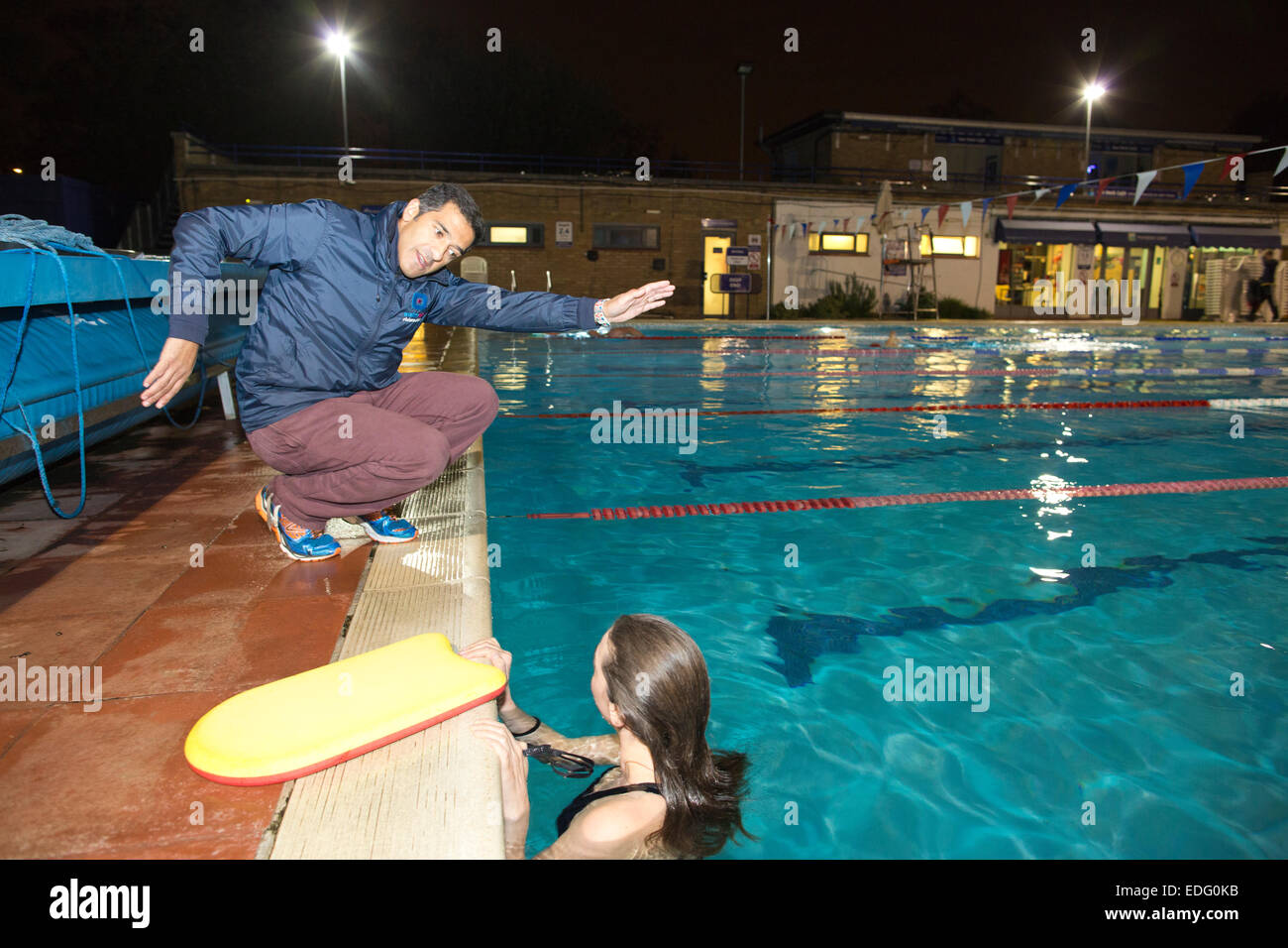Evening swimming lessons given by Salim Ahmed outdoors at Hampton Pool, Middlesex, England, UK Stock Photo