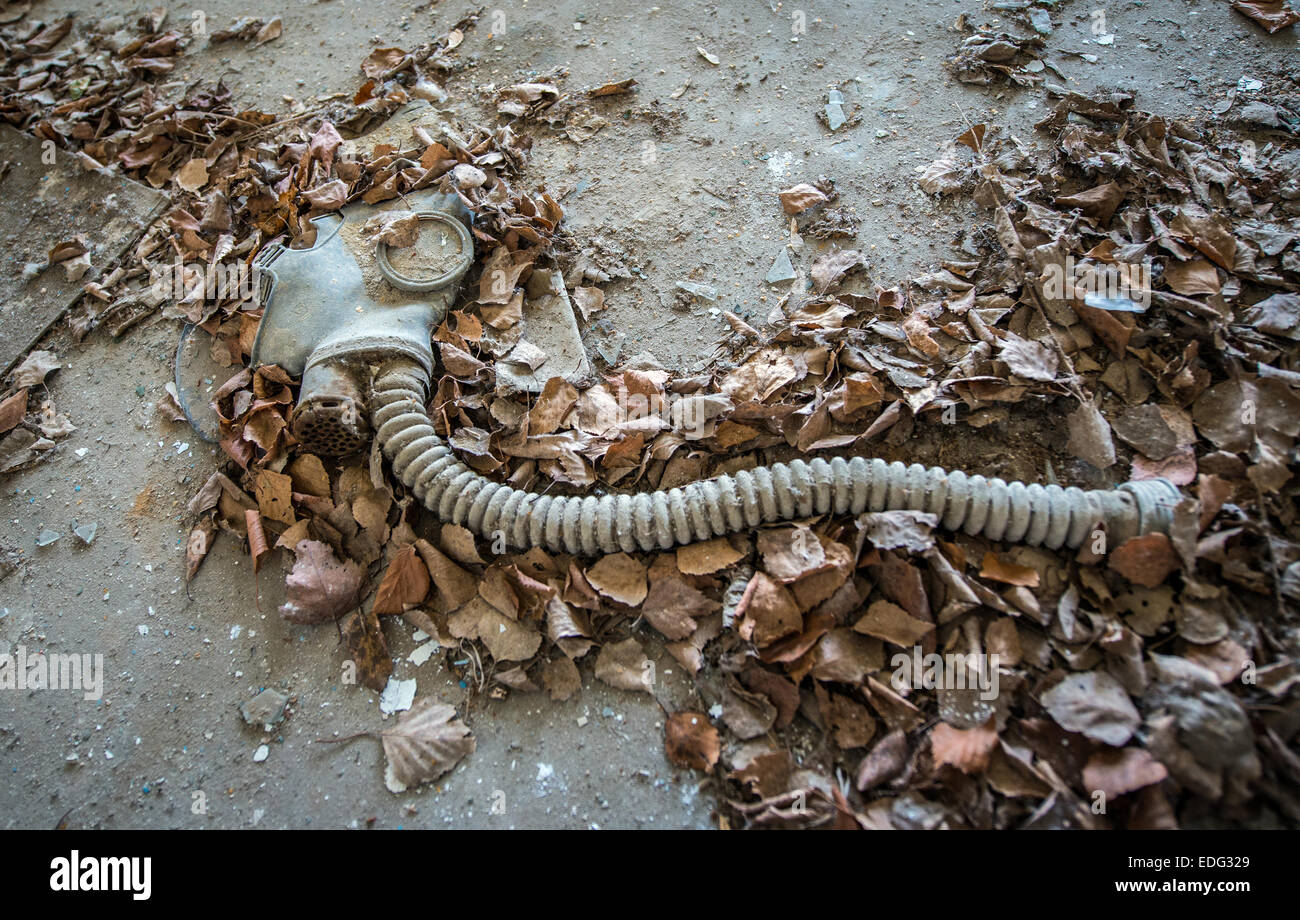 old gas mask from cold war period in abandoned school in Illinci (or Ilintsy) village, Chernobyl Exclusion Zone, Ukraine Stock Photo
