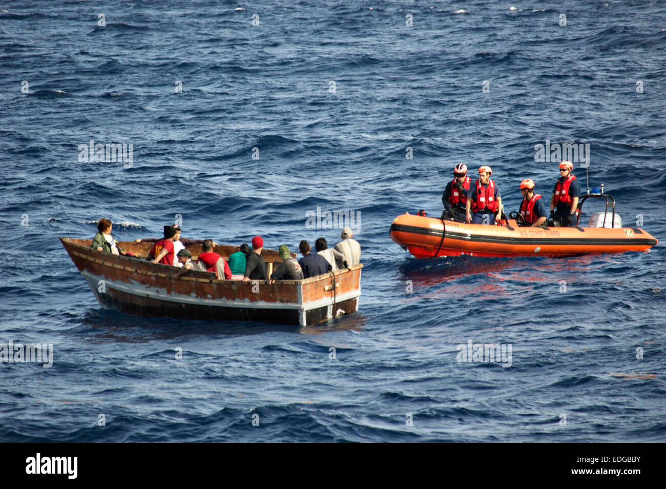 Members of the US Coast Guard Cutter Knight Island approach a boat with 12 Cuban migrants December 30, 2014 southwest of Key West, Florida. The U.S. Coast Guard reports that the number of Cubans picked up at sea trying to reach the United States has surged since President Barack Obama announced plans to restore diplomatic relations with Havana. Stock Photo