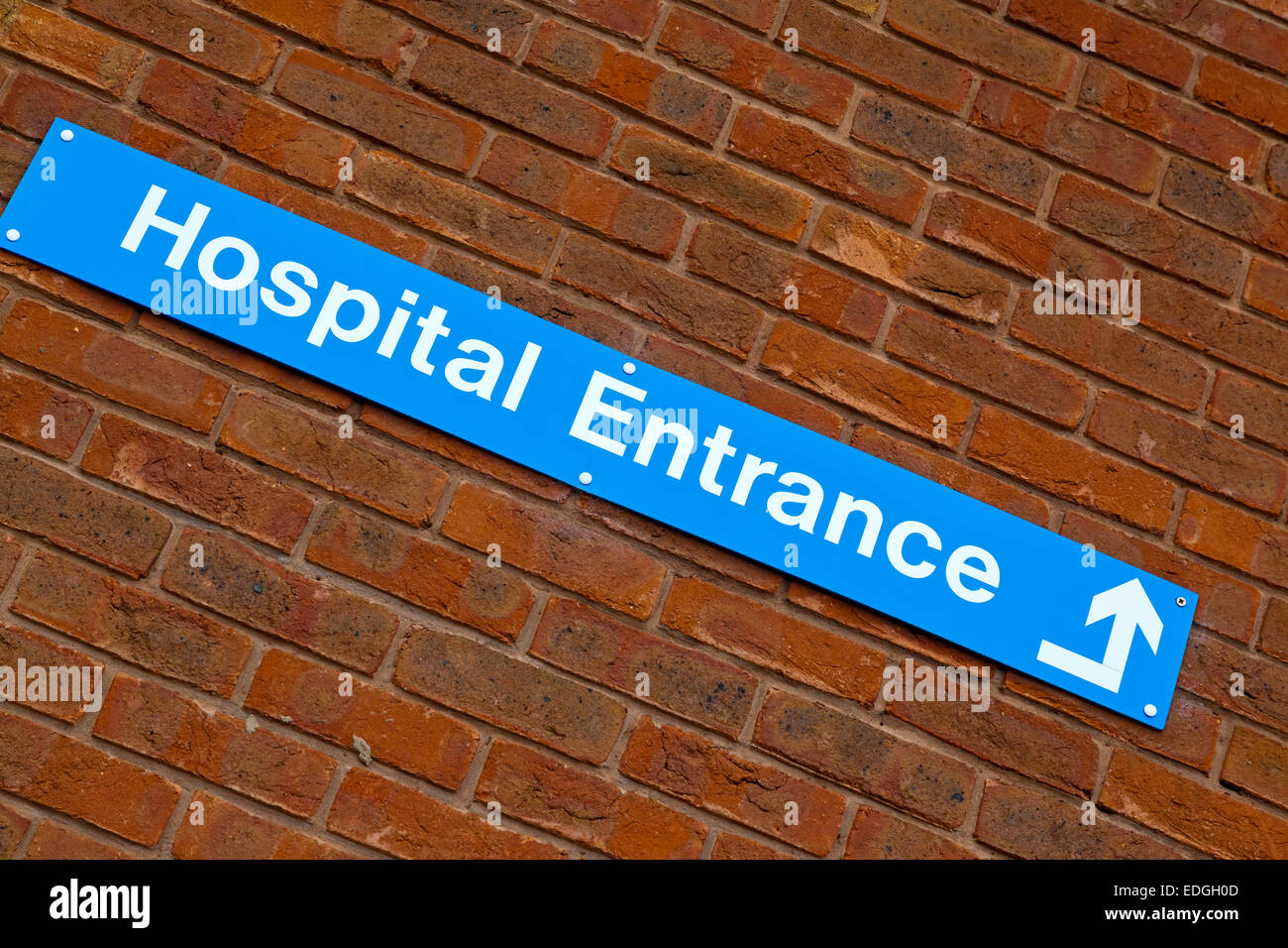 Hospital Entrance sign on a brick wall outside a British National Health Service NHS Hospital Stock Photo