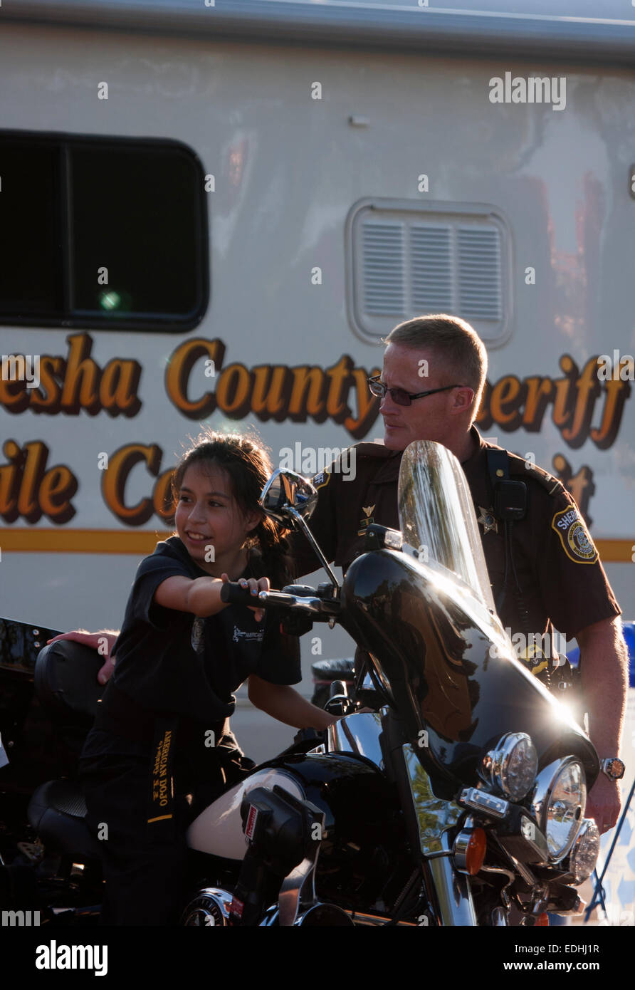 Waukesha County Sheriff motocycle officer with a child at National Night Out in WI Stock Photo