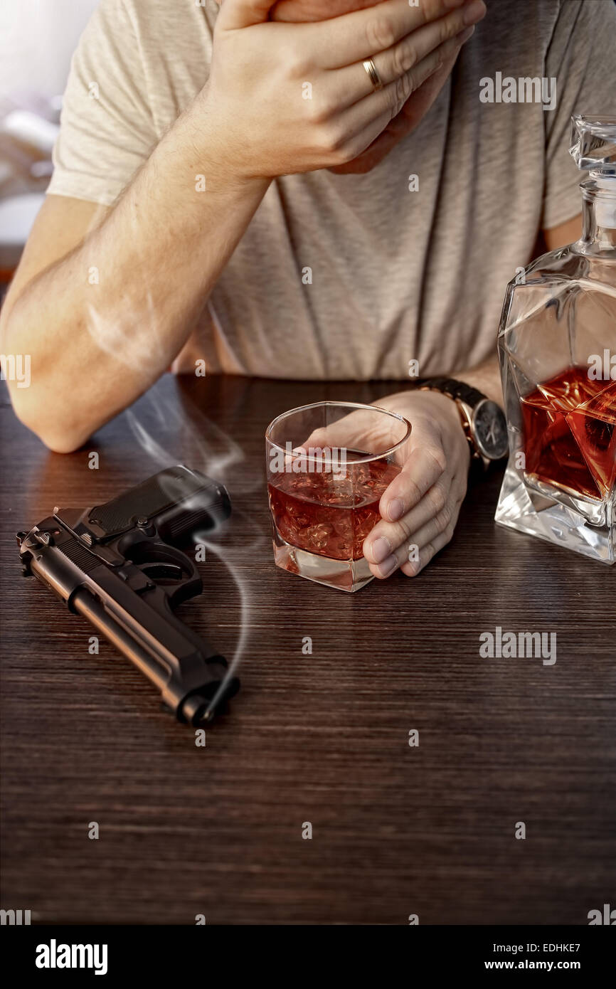 Devastated man with a gun and alcohol Stock Photo Alamy