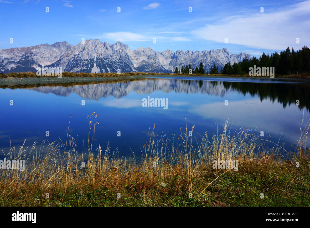 Wilder Kaiser mountains reflecting in artifical pond used for artifcial snow production, Hartkaiser ski area. Tirol, Austria Stock Photo