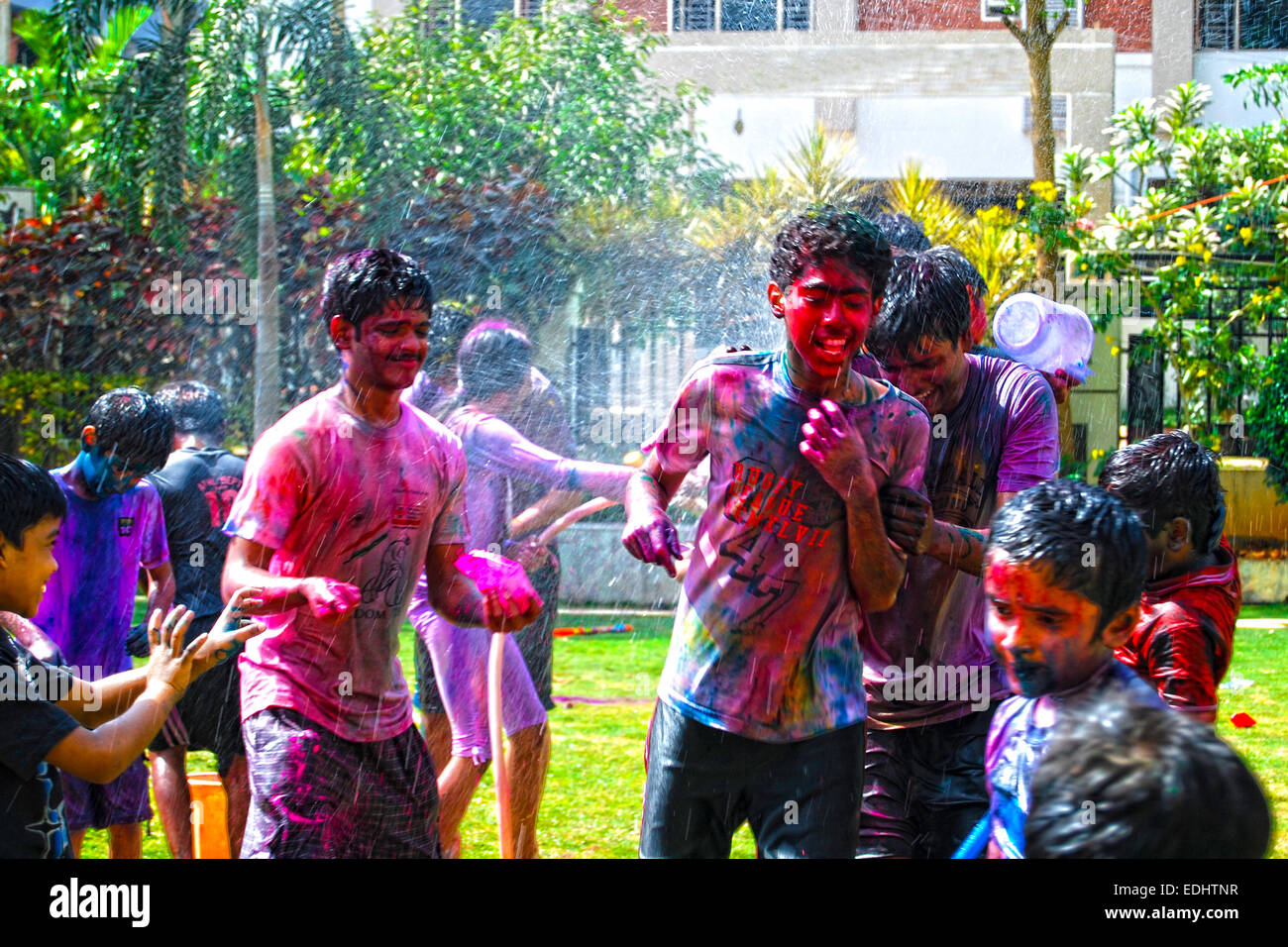 Group of young boys playing with powder colors & water during the spring hindu festival Holi also known as a festival of colors. Stock Photo