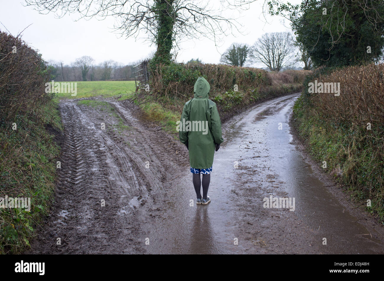 A woman stands on a country lane Stock Photo
